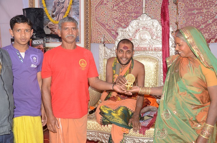 Swamigal blessing a family with the sacred idol at the Ashram